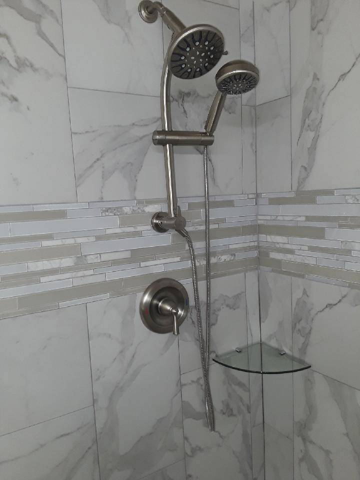 Marble shower with a handheld fixture and niche