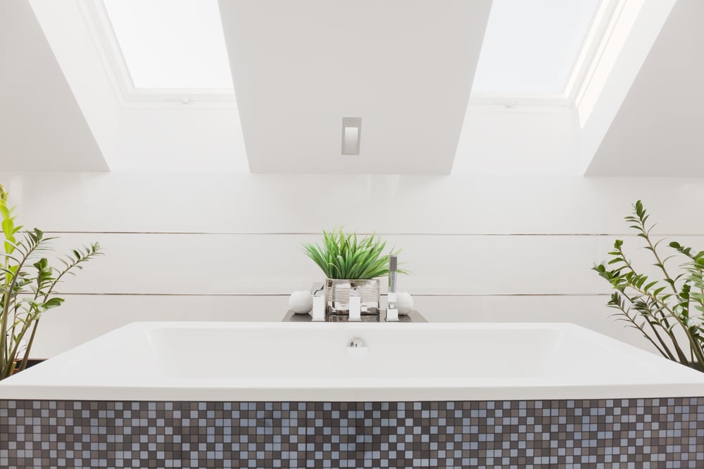 Modern furnished bathroom with chrome fixtures and tub area